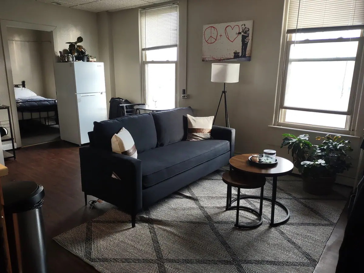 Rental living room with a dark sofa, floors and surfaces done