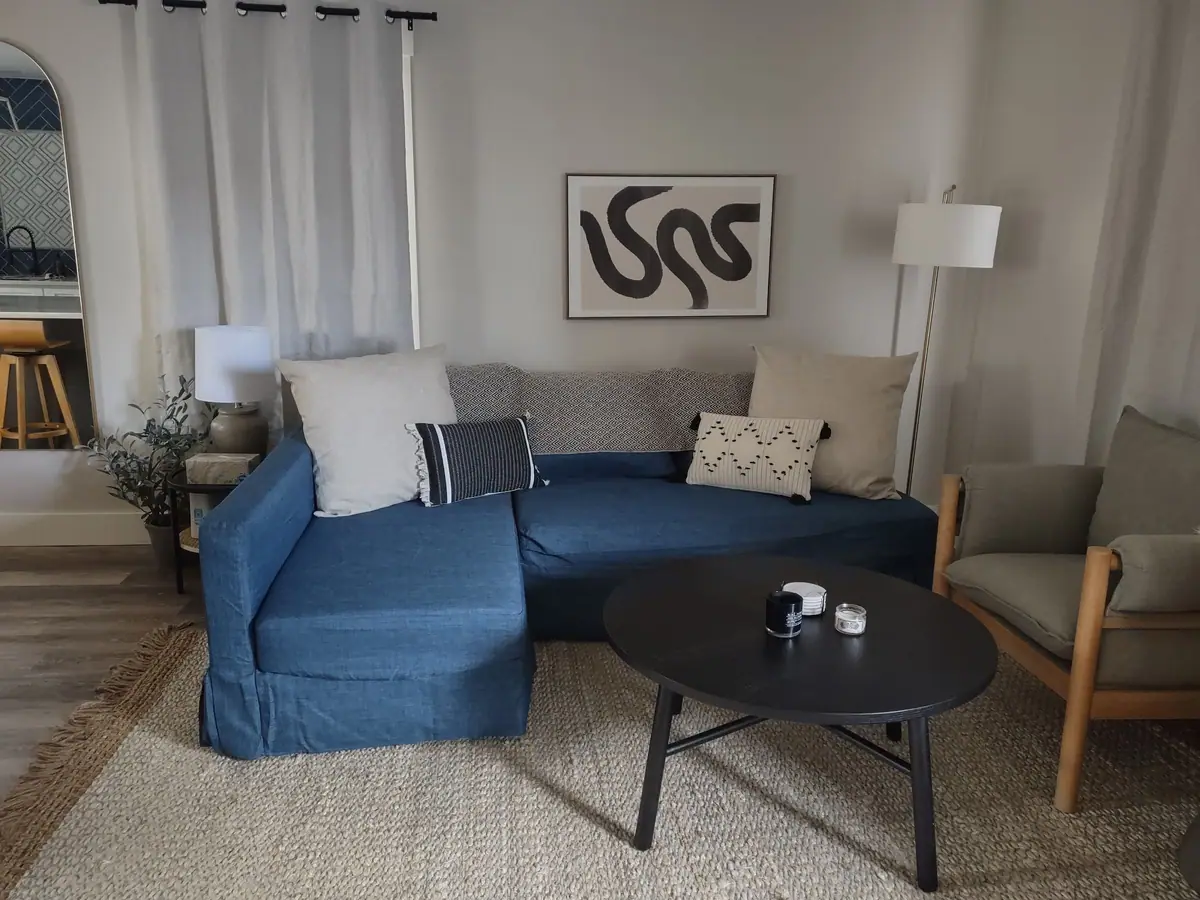Bright living room with a blue sofa, tidied and dusted