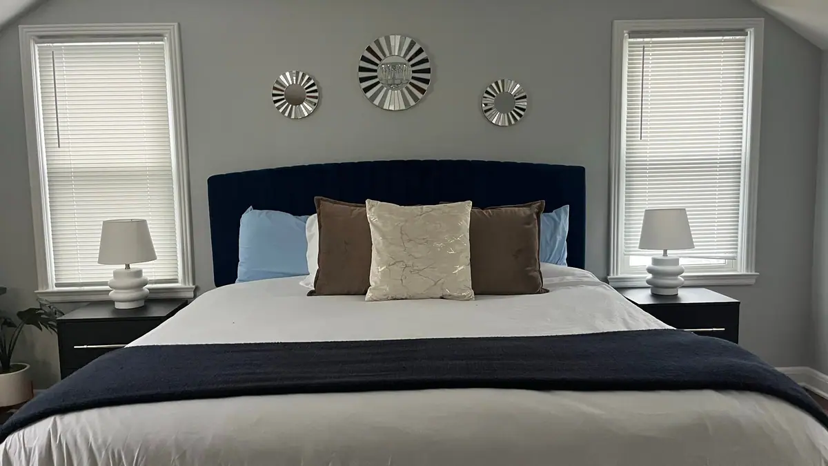 Guest bedroom with a navy headboard and crisp white bedding