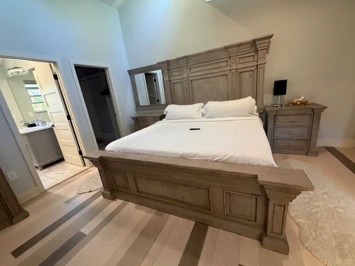 King suite made up with white bedding, the en-suite bath beyond