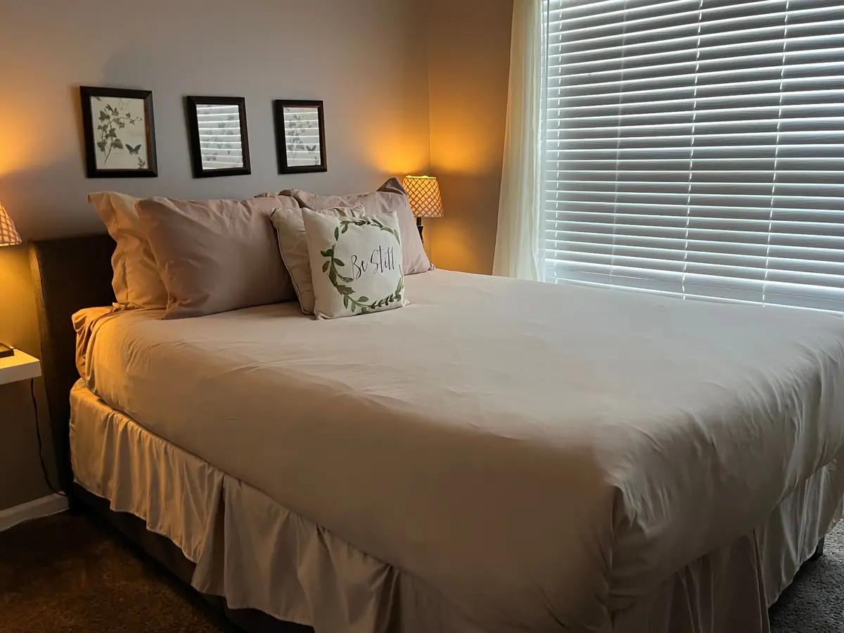Guest bedroom with a made bed and soft lamplight
