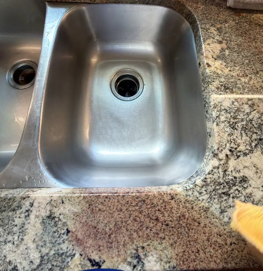 Polished stainless kitchen sink set in a granite counter