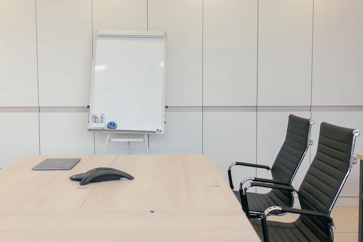 Clean meeting room table with chairs and a whiteboard (stock photo)