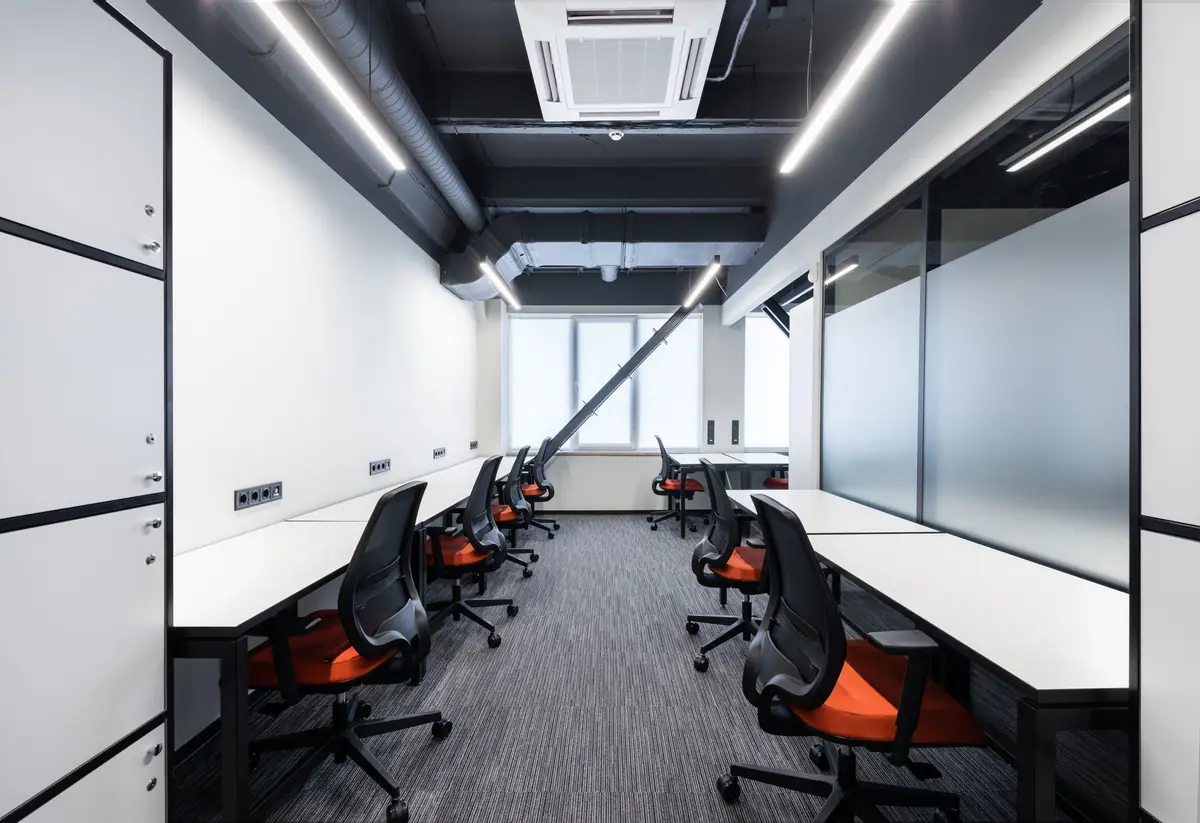 Empty open-plan office with clean white desks and chairs (stock photo)
