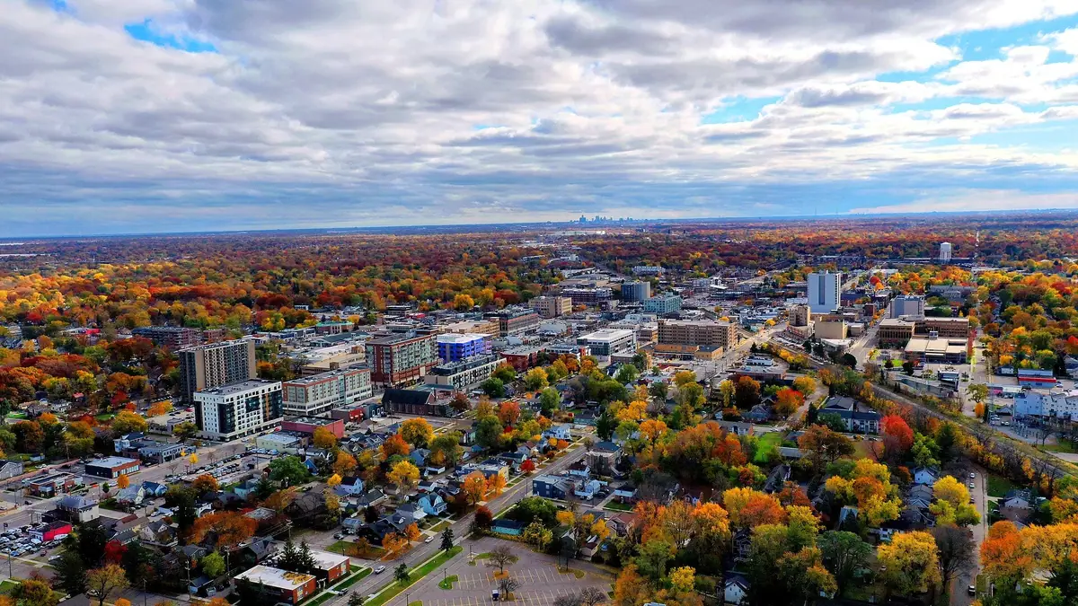 Autumn aerial view of downtown Royal Oak and its tree-lined neighborhoods, with the Detroit skyline in the distance