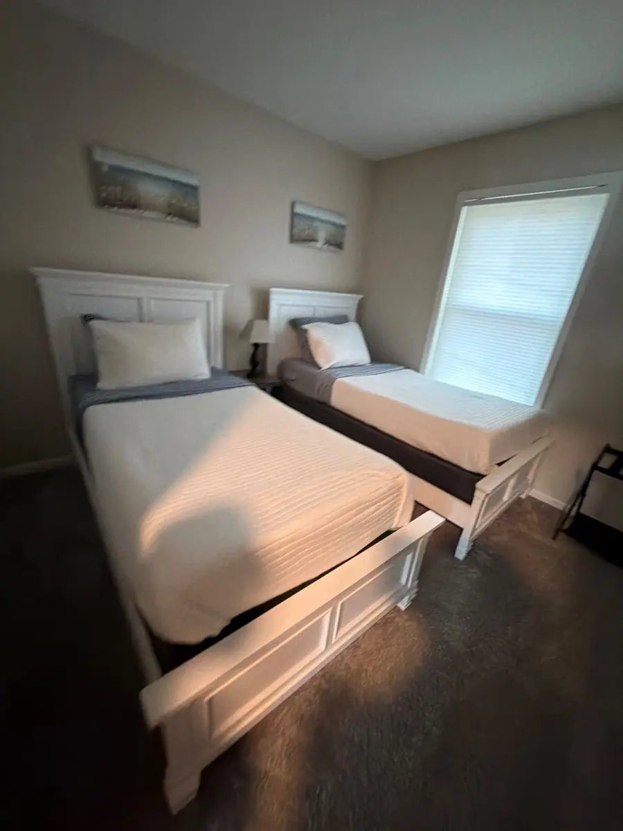 Twin beds made with crisp white quilts and blue sheets