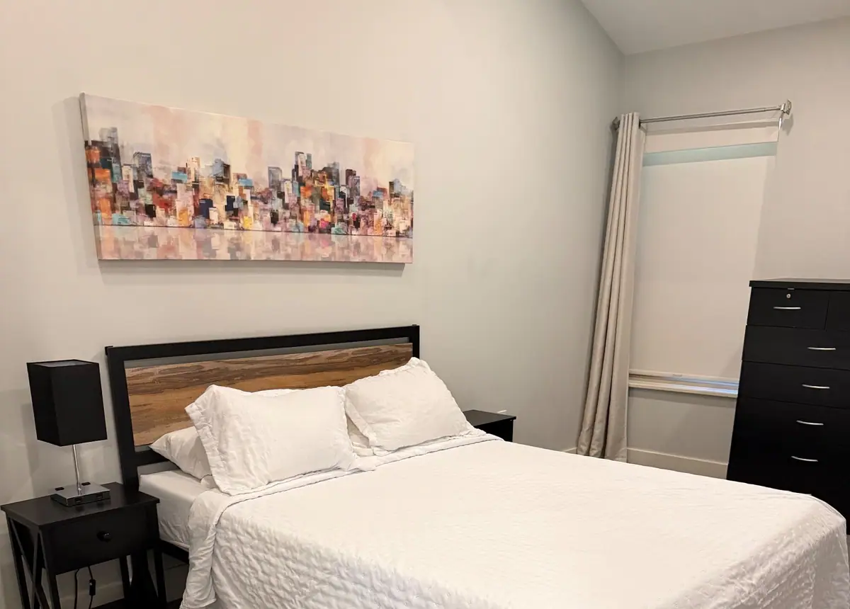 Guest bedroom with a fresh white quilt and black nightstands